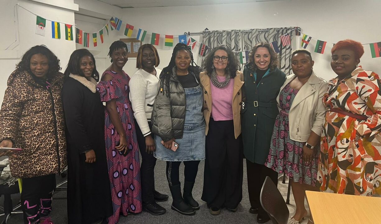 Group photo showing some of the speakers and attendees of the event, with flags from African nations in the background